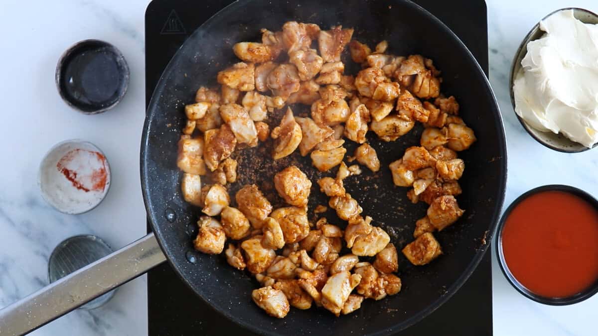 Searing chicken to make a buffalo chicken pasta bake.