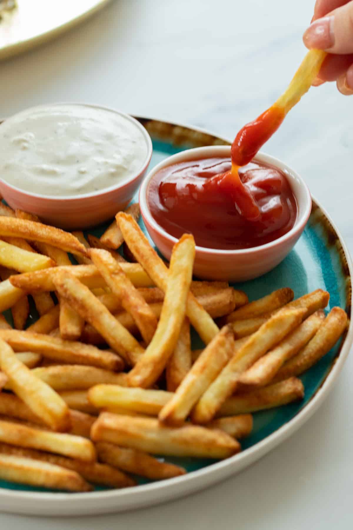 a french fry being dipped in ketchup.