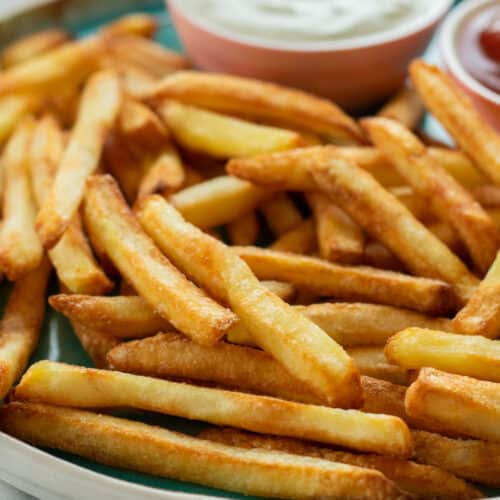 close up of french fries on a plate.