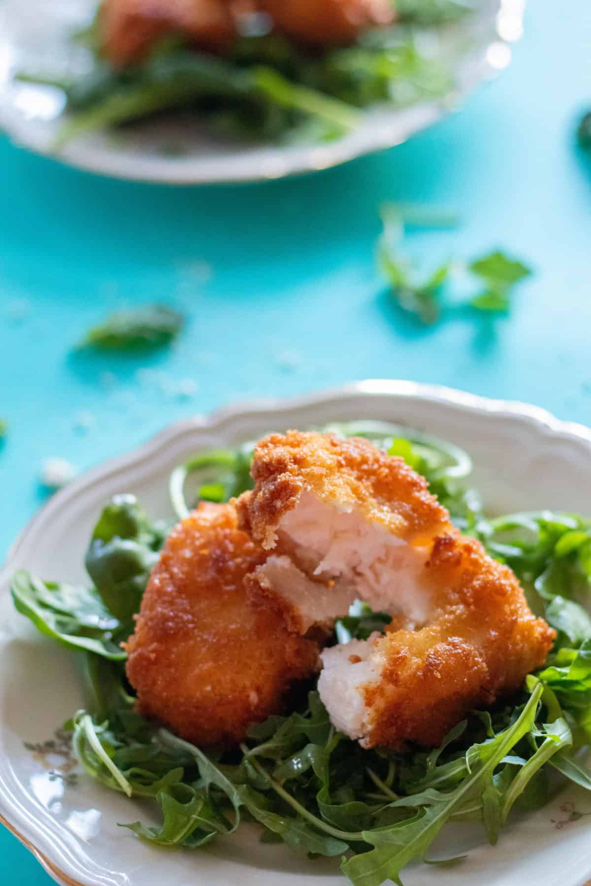 fried feta cheese on a bed of arugula