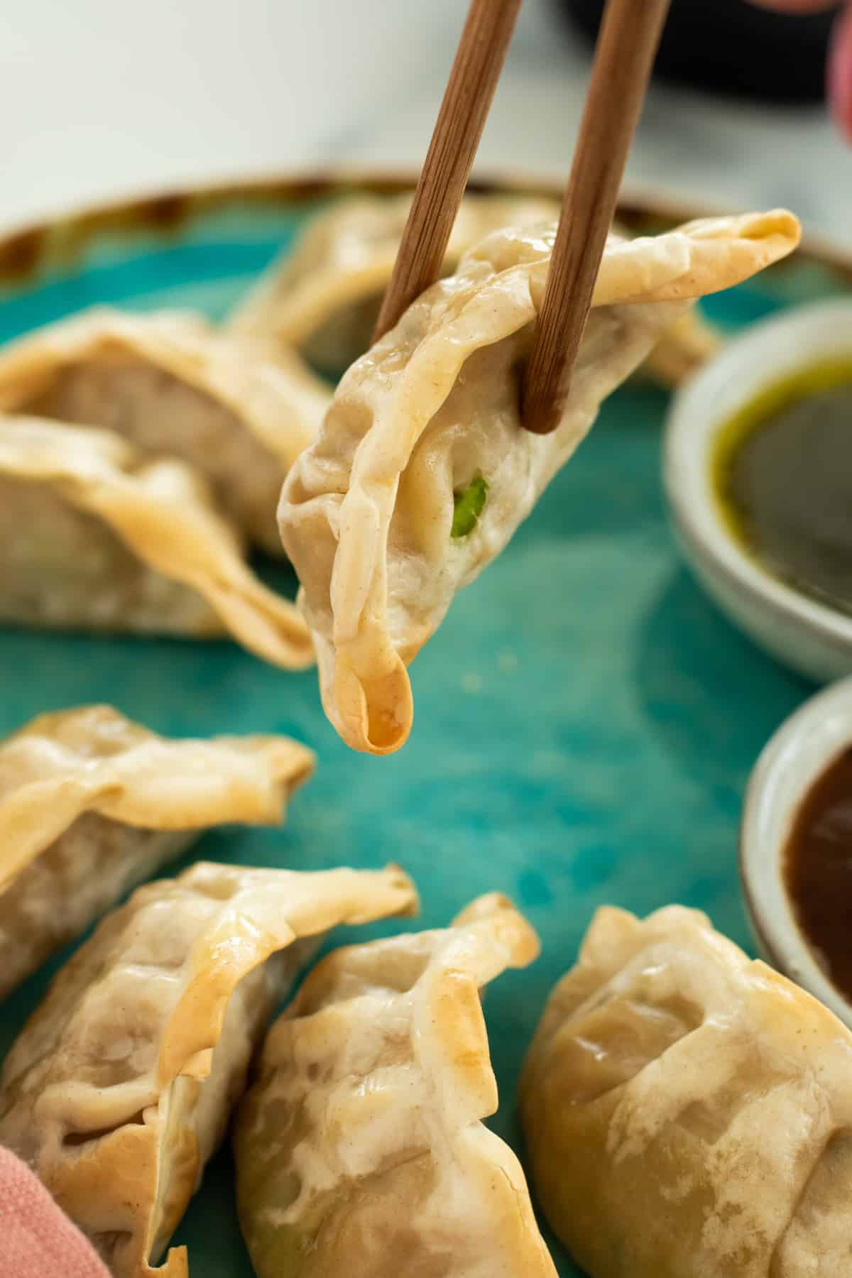 a dumpling being picked up with chopsticks.