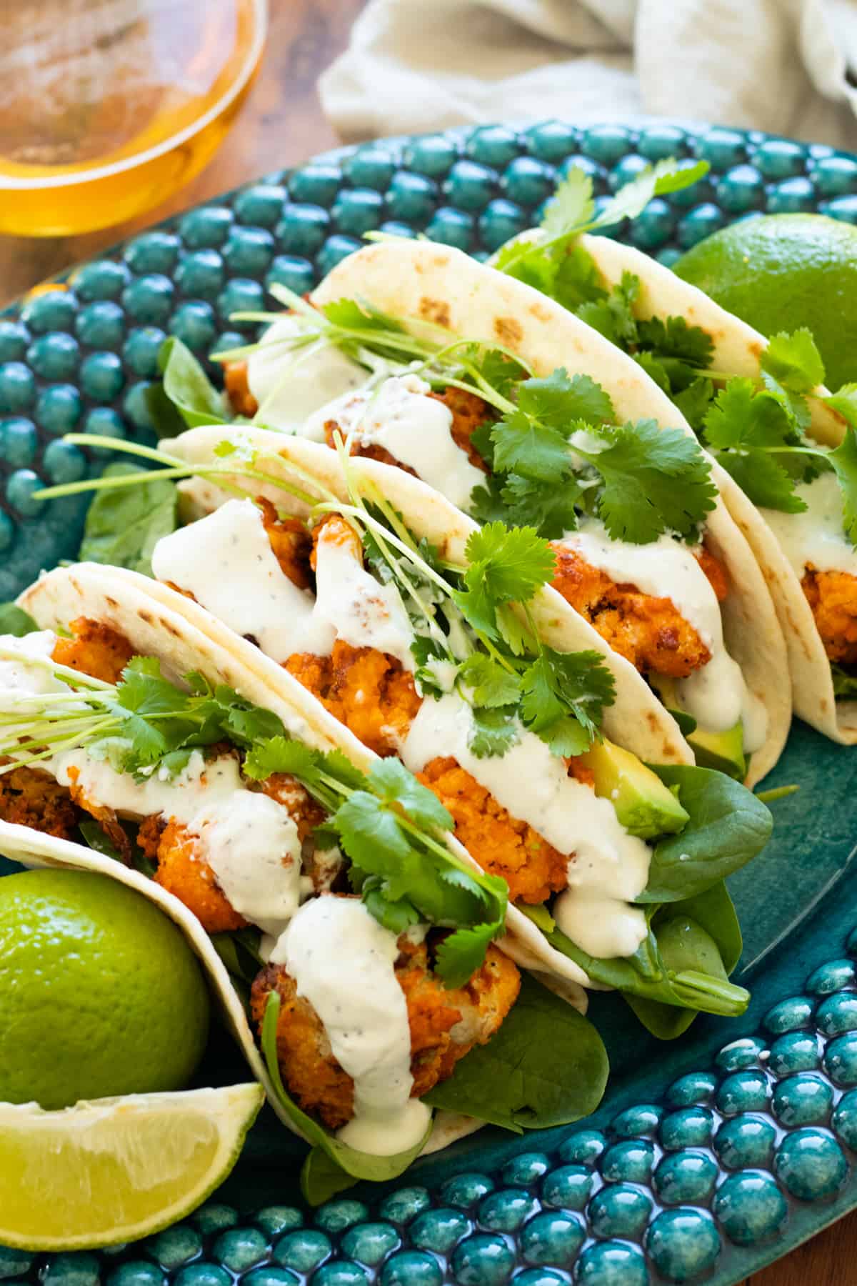 buffalo cauliflower tacos on a blue plate.