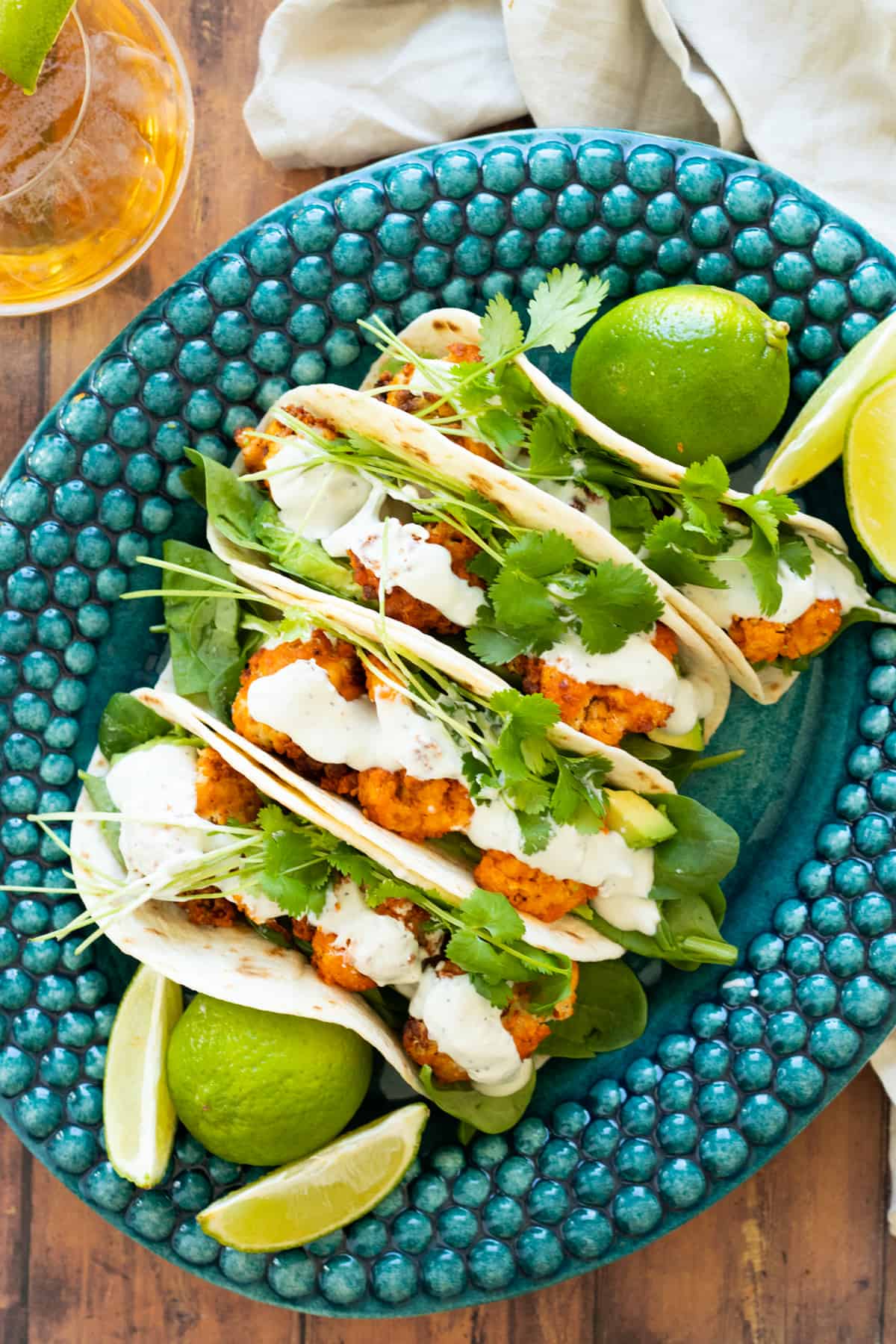 buffalo cauliflower tacos on a blue plate.