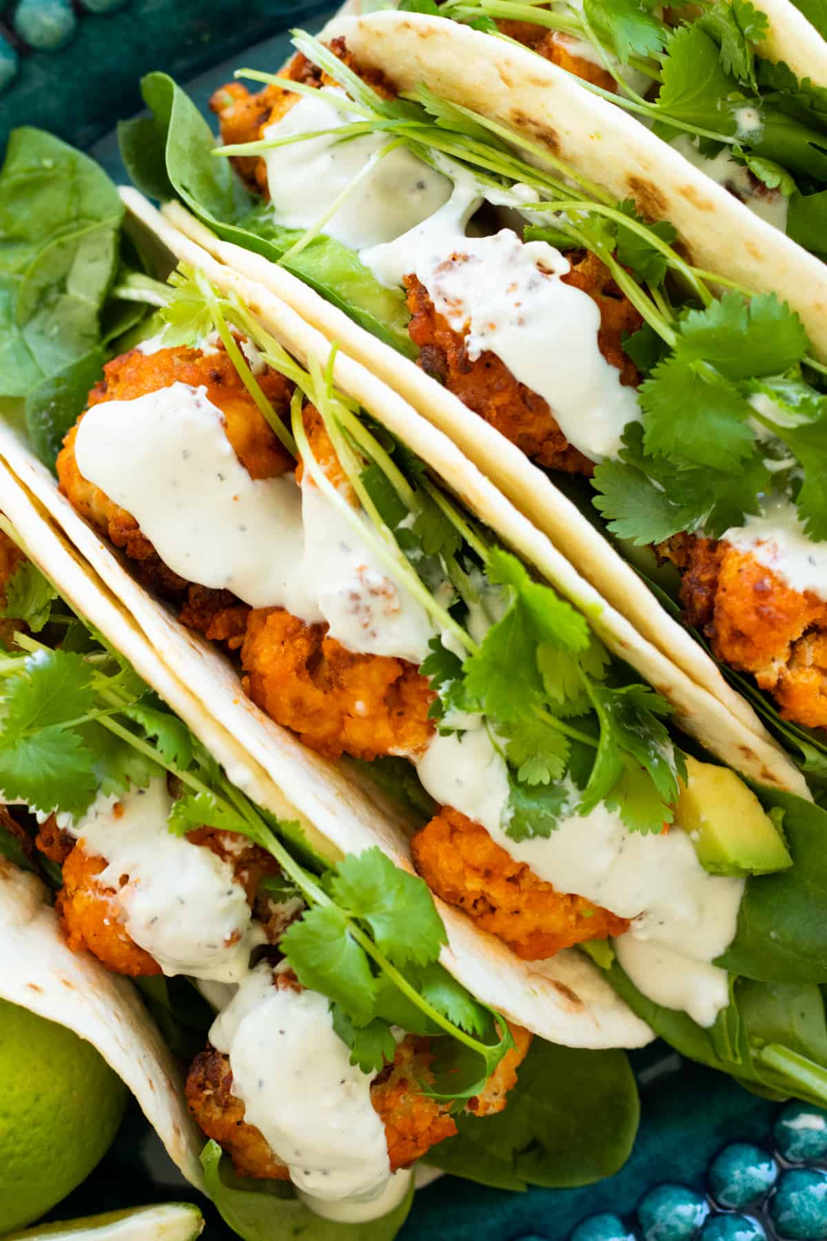 buffalo cauliflower tacos on a blue plate.