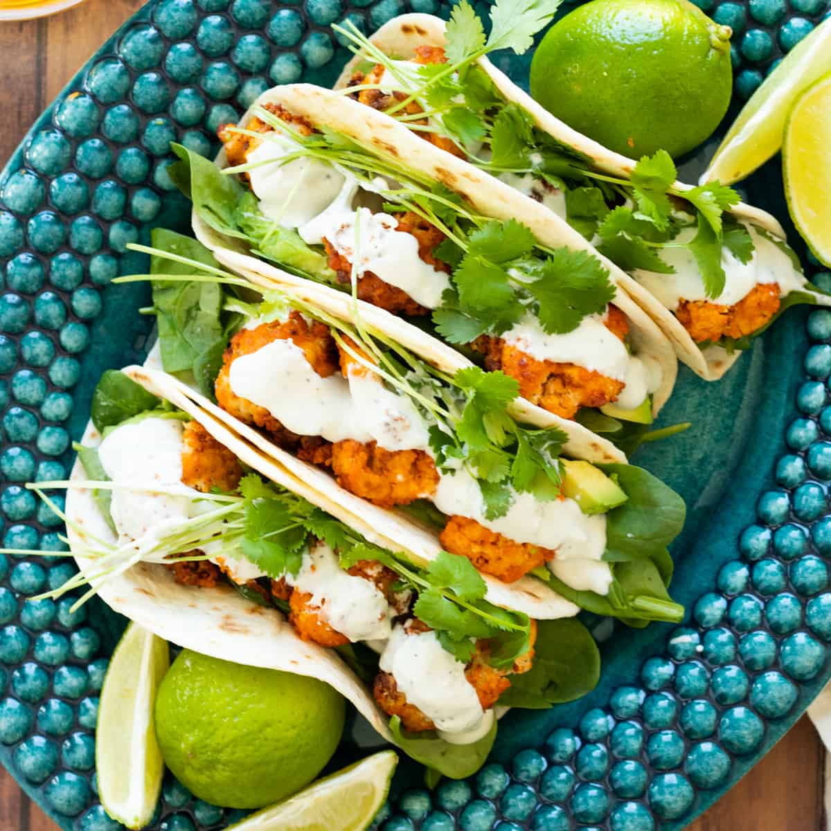 buffalo cauliflower tacos on a blue plate.