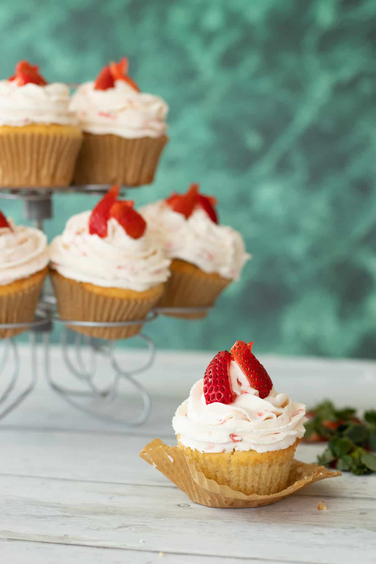 strawberry filled cupcakes topped with strawberries.