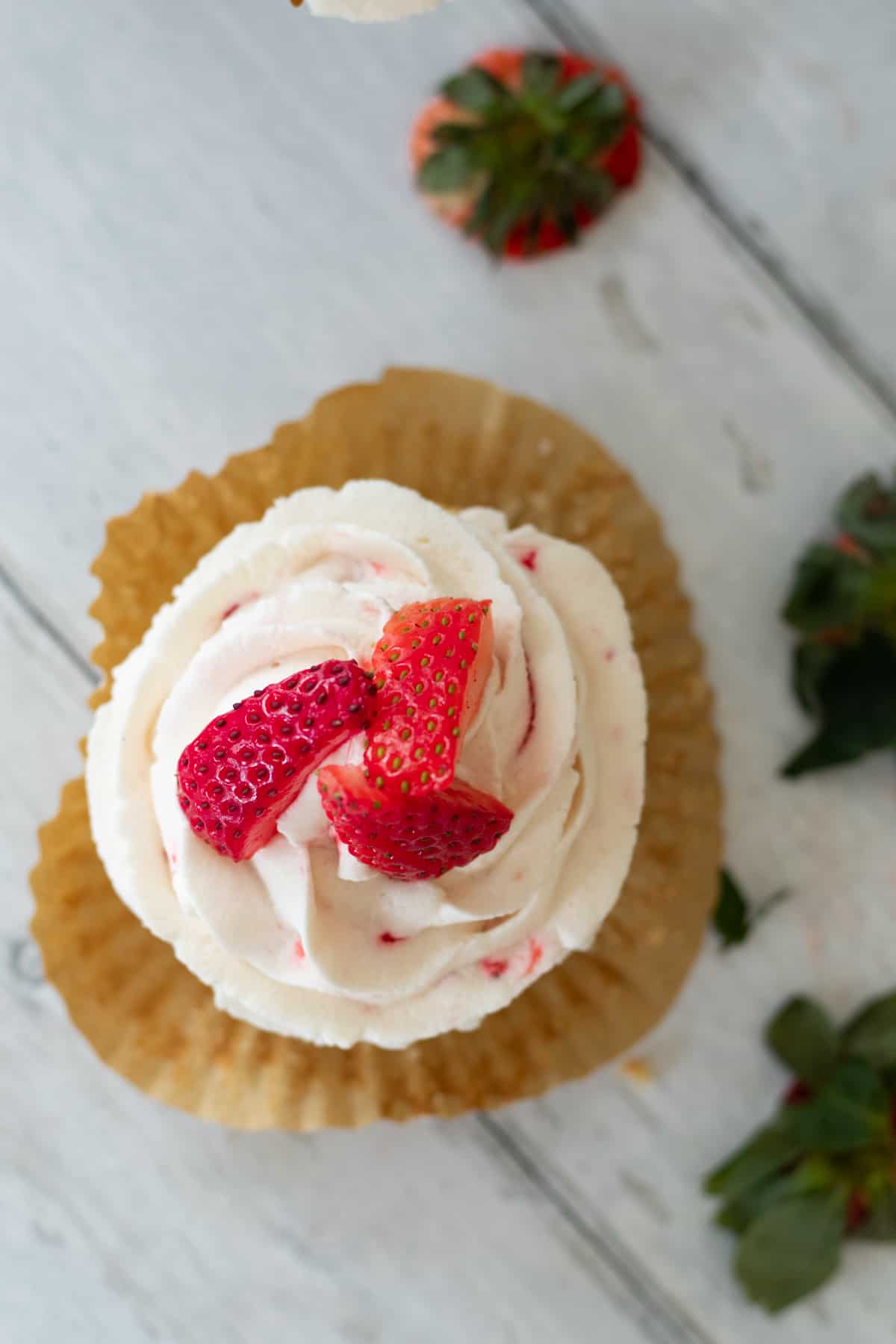 a strawberry filled cupcake topped with strawberries.