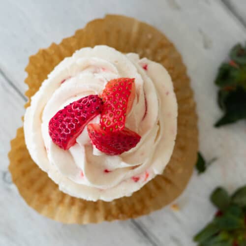 a strawberry filled cupcake topped with strawberries