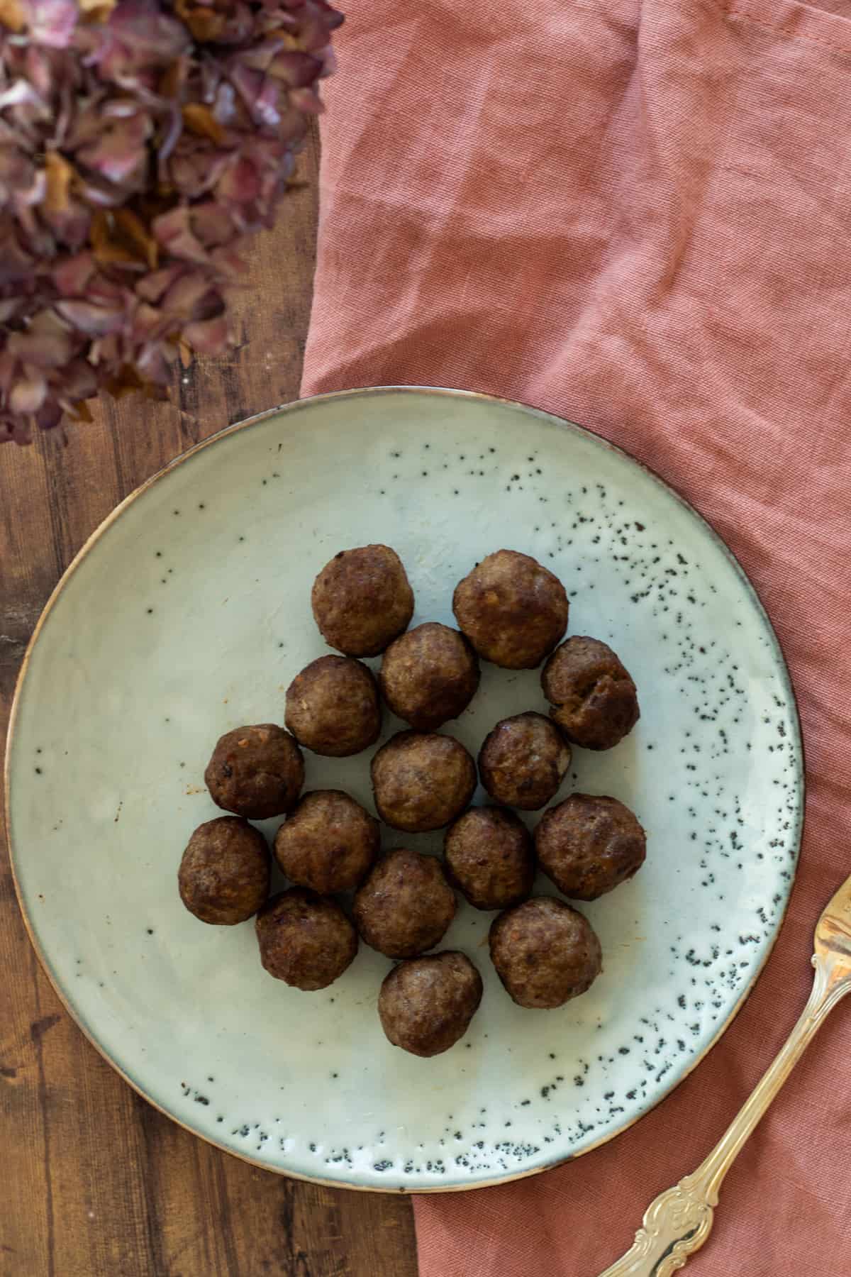 frozen meatballs cooked in air fryer on a blue plate