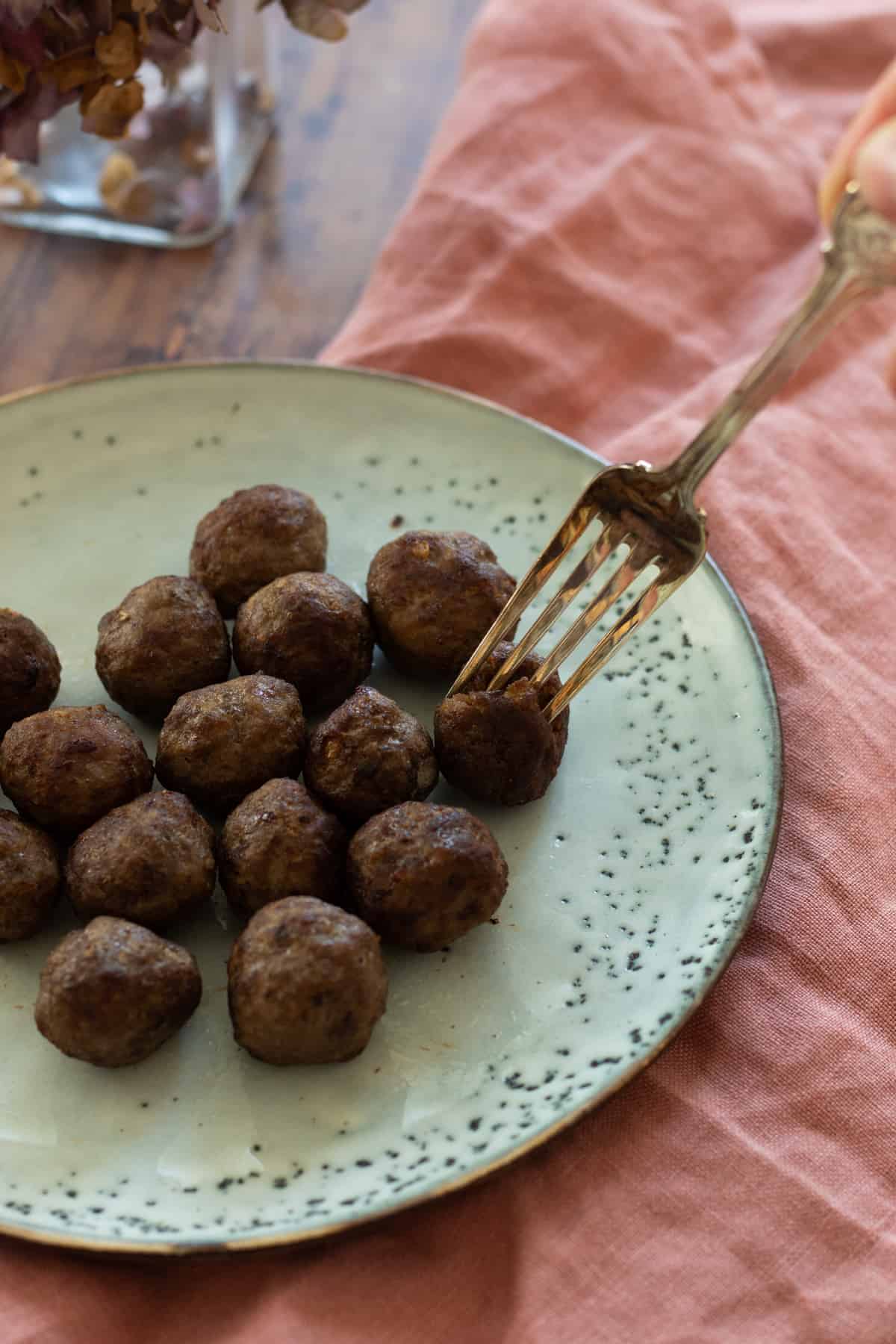 frozen meatballs cooked in air fryer on a blue plate