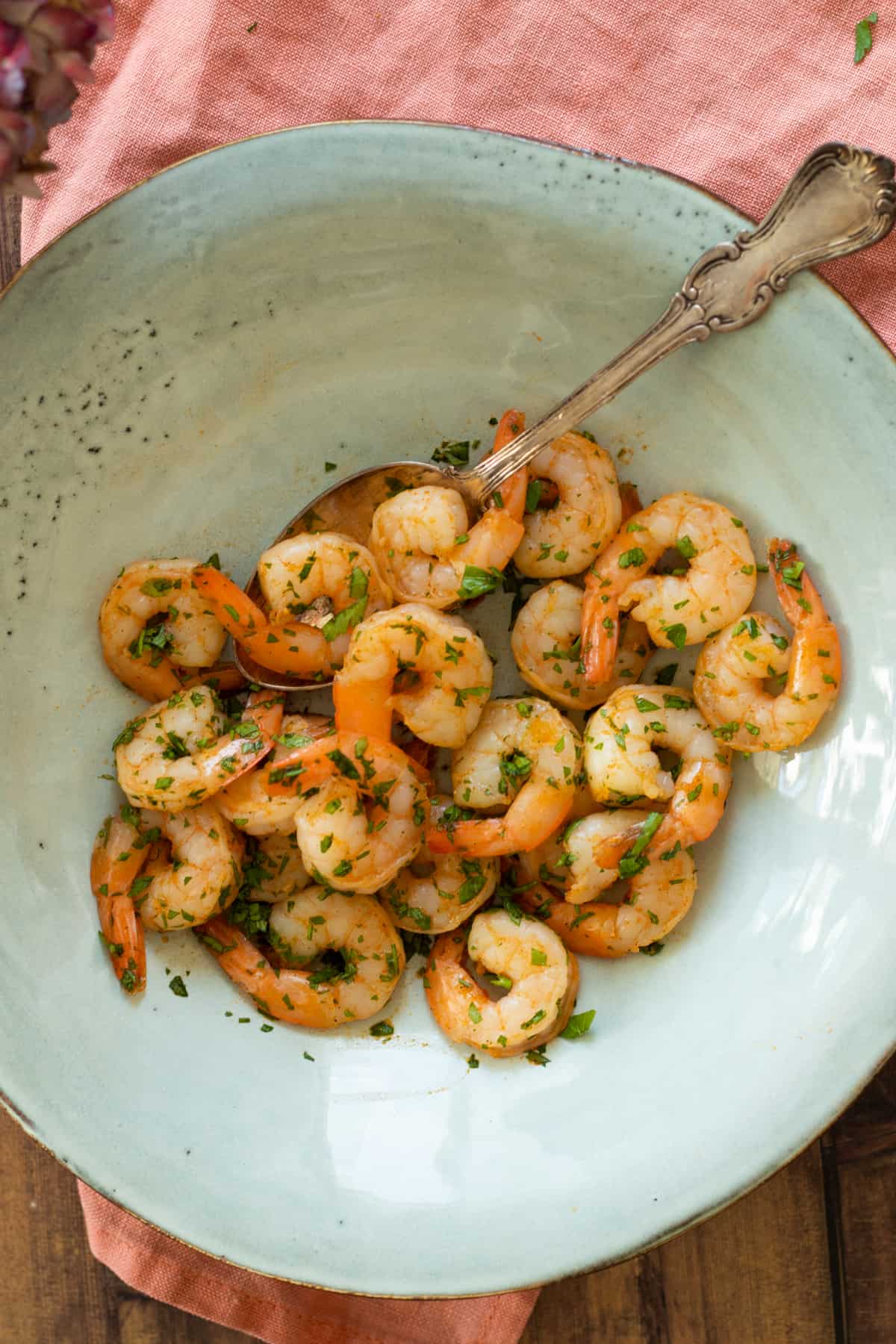 air fryed shrimp with parsley on a blue plate.