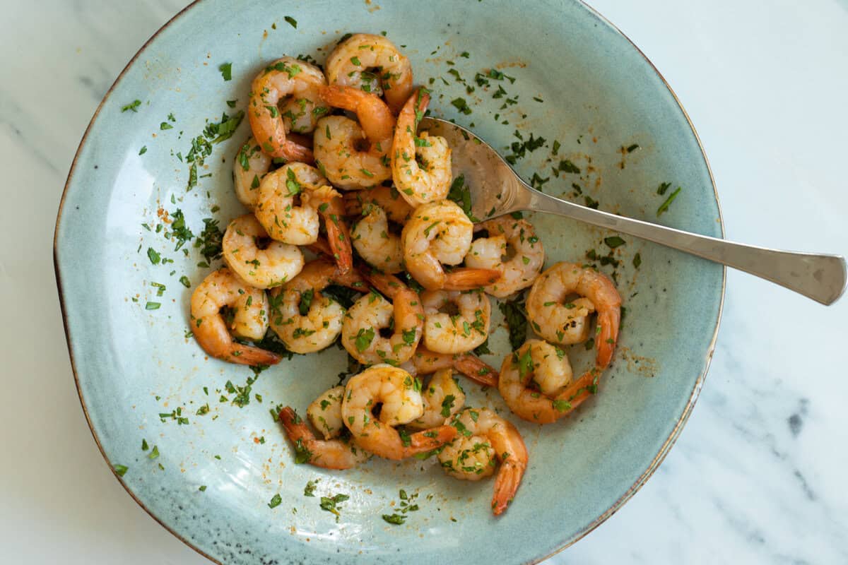 Air fried shrimp with parsley on a blue plate.