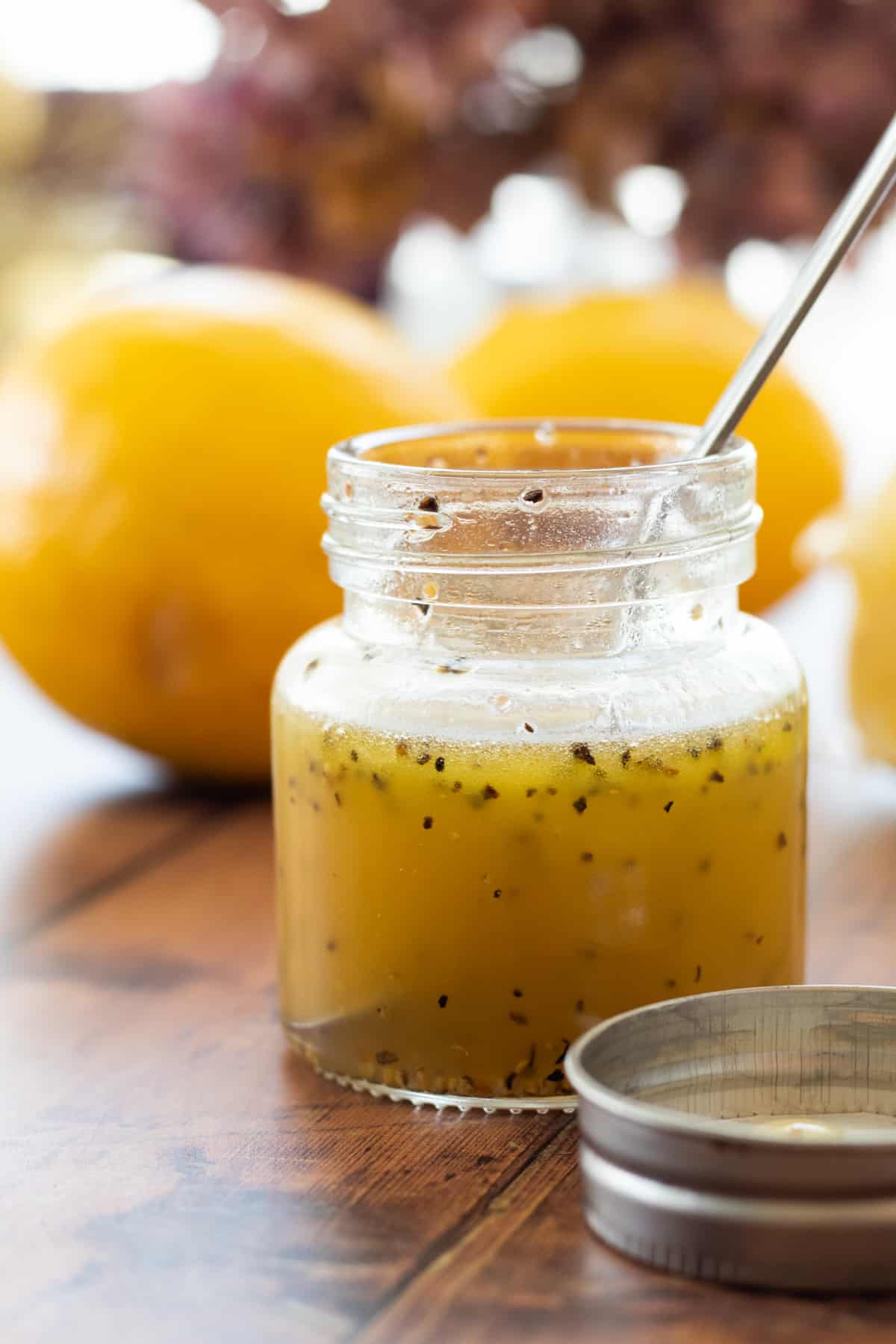 honey lemon vinaigrette in a jar with a spoon.