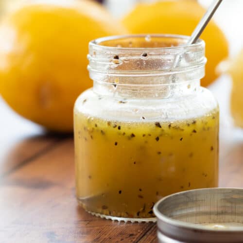 honey lemon vinaigrette in a jar with a spoon