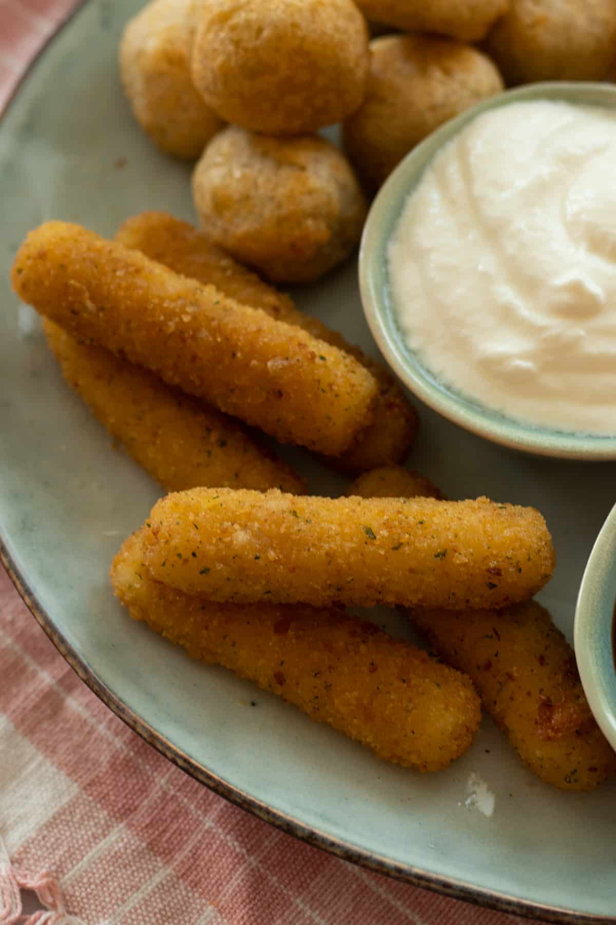 air fried mozzarella sticks on a late with dipping sauces.