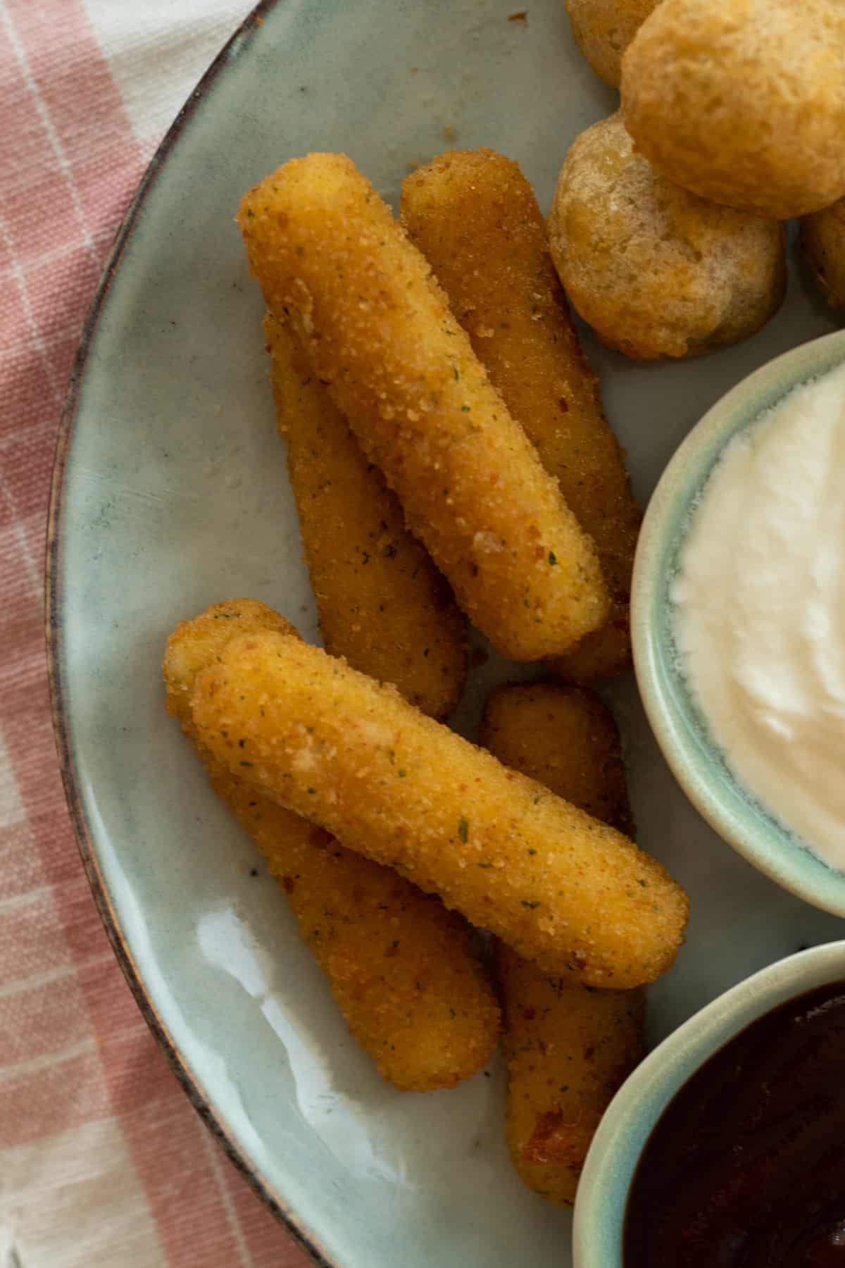 air fried mozzarella sticks on a late with dipping sauces