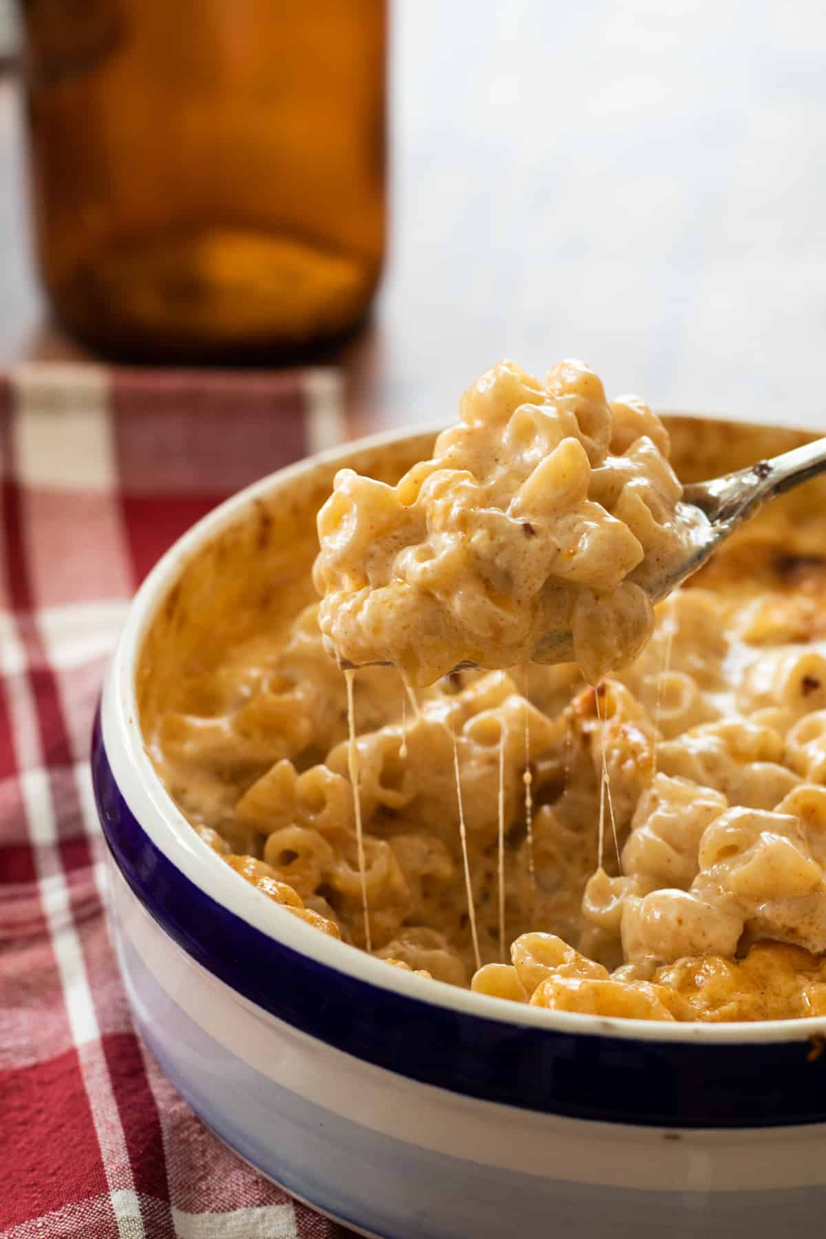 a spoonful of mac and cheese being lifted out of the pan