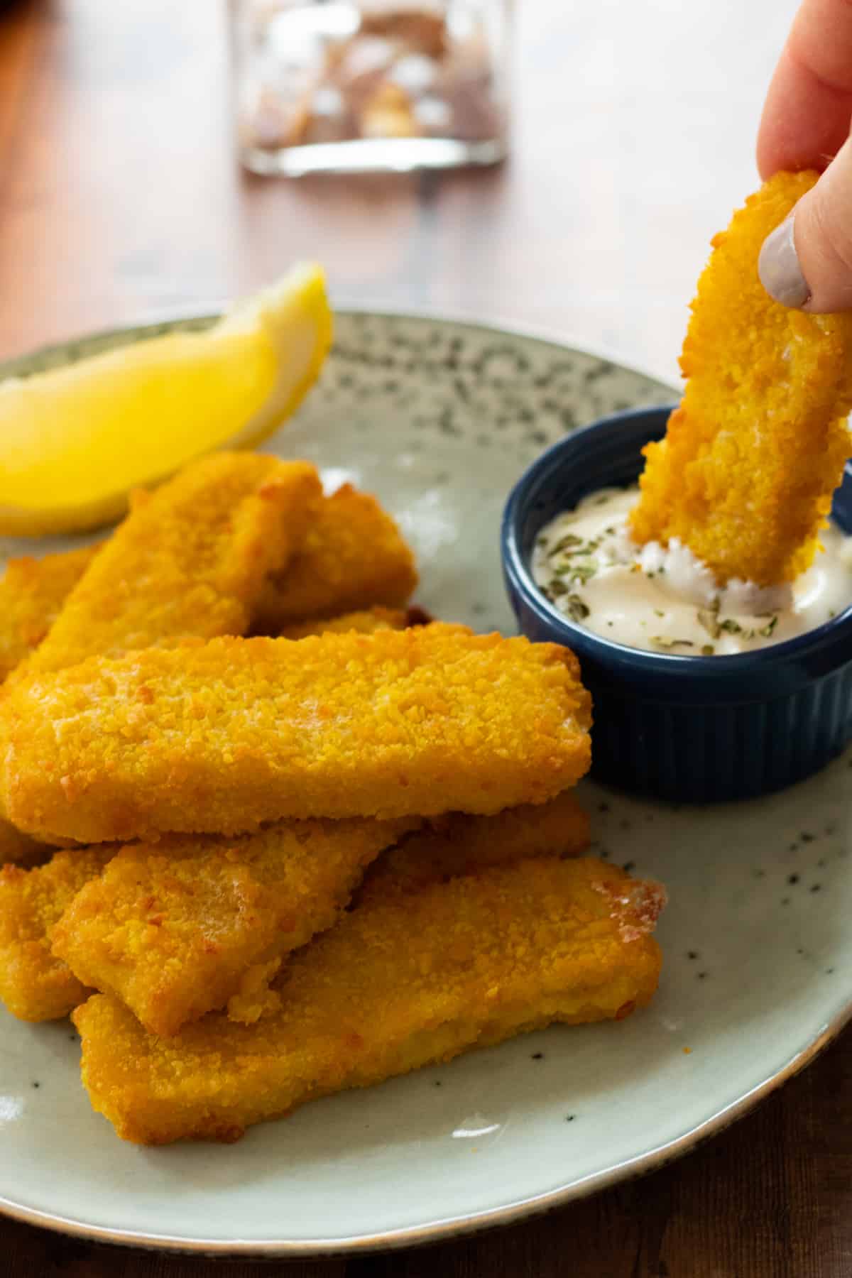 air fried fish sticks on a blue plate with dipping sauce