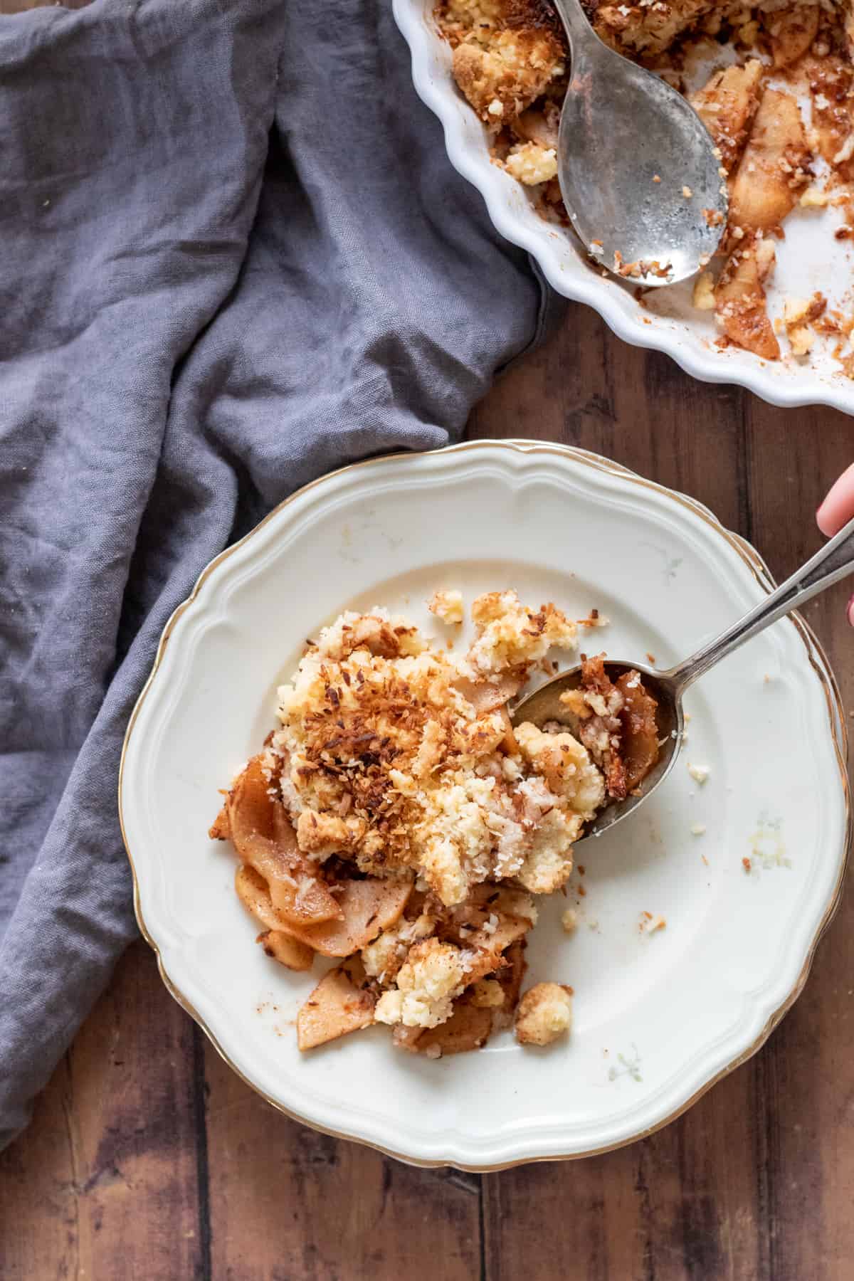 apple crisp without oats on a white plate with a spoon.