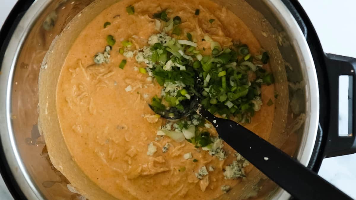 adding blue cheese and scallions to sauce