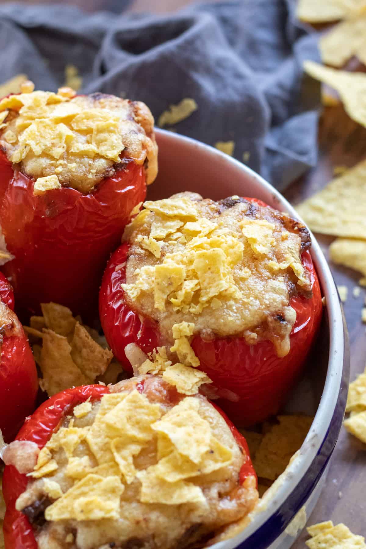 stuffed bell peppers without rice in a baking dish, topped with tortilla chips