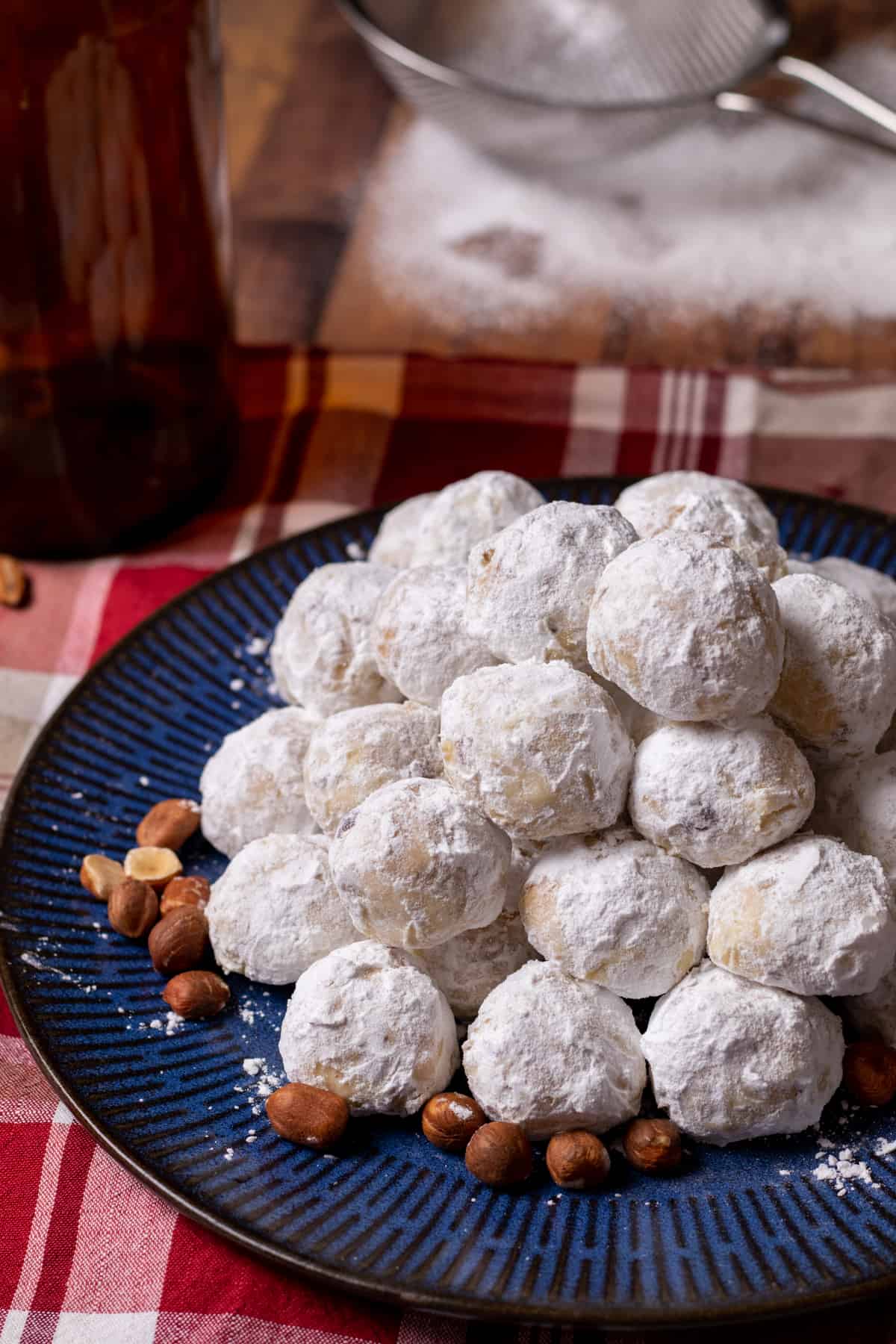 butterball cookies on a blue plate with hazelnuts.