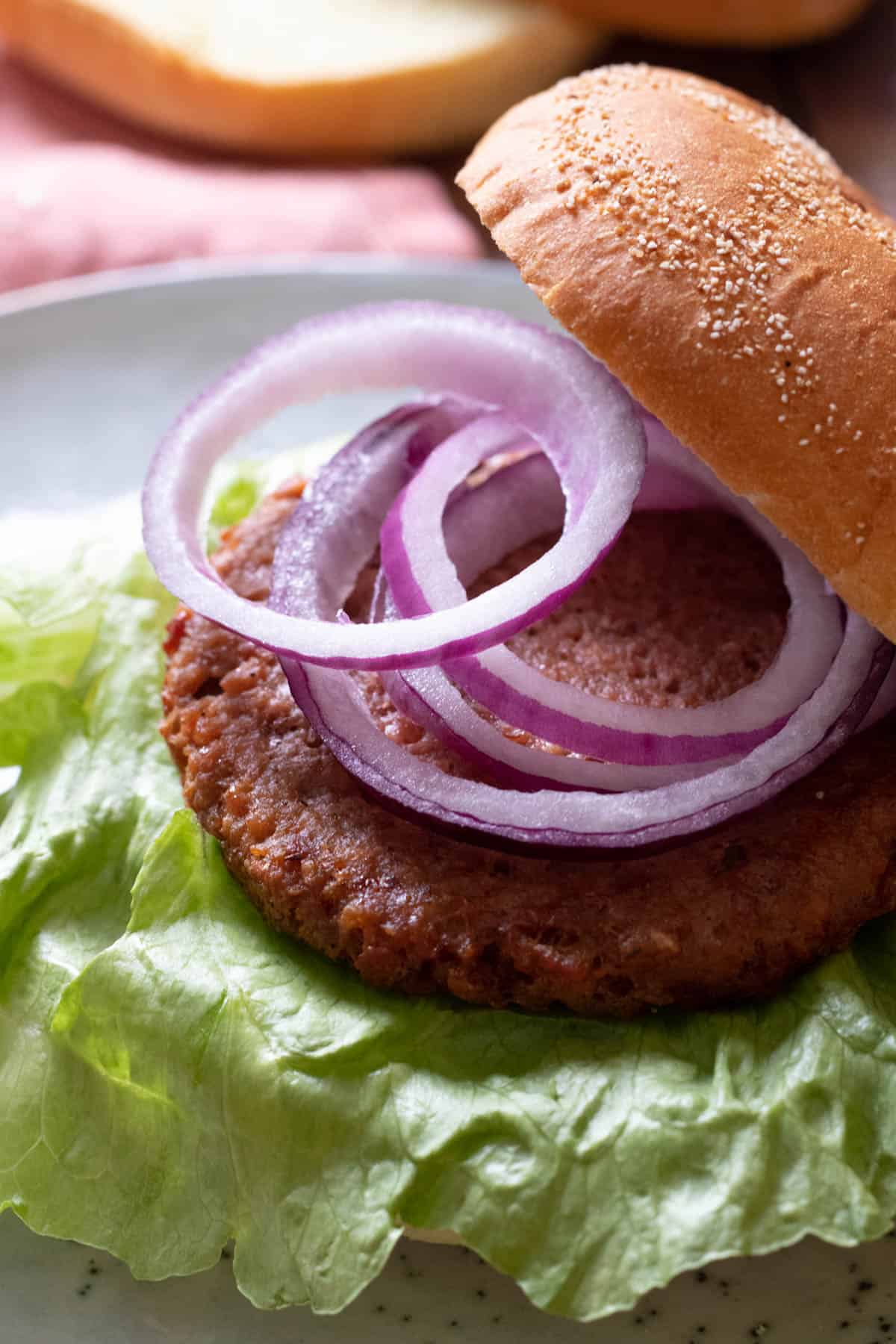 a veggie burger topped with red onion