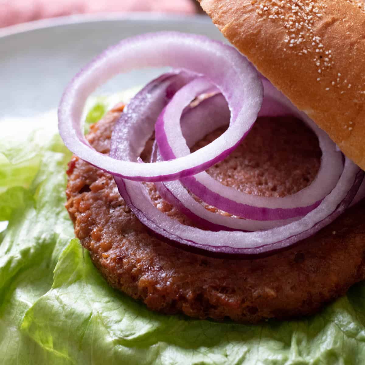 a veggie burger topped with red onion