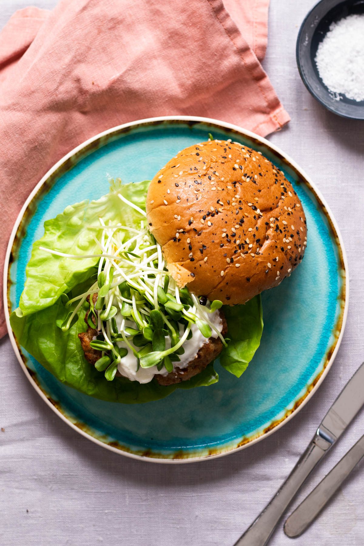 A turkey burger on a blue plate.