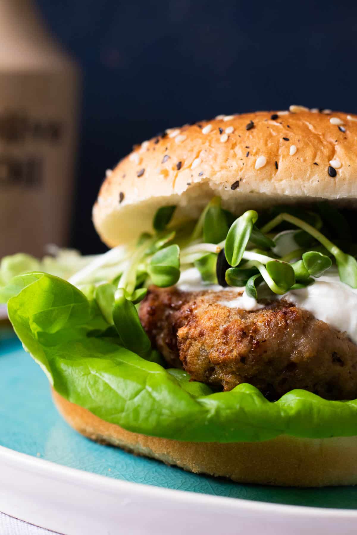 A turkey burger on a blue plate.