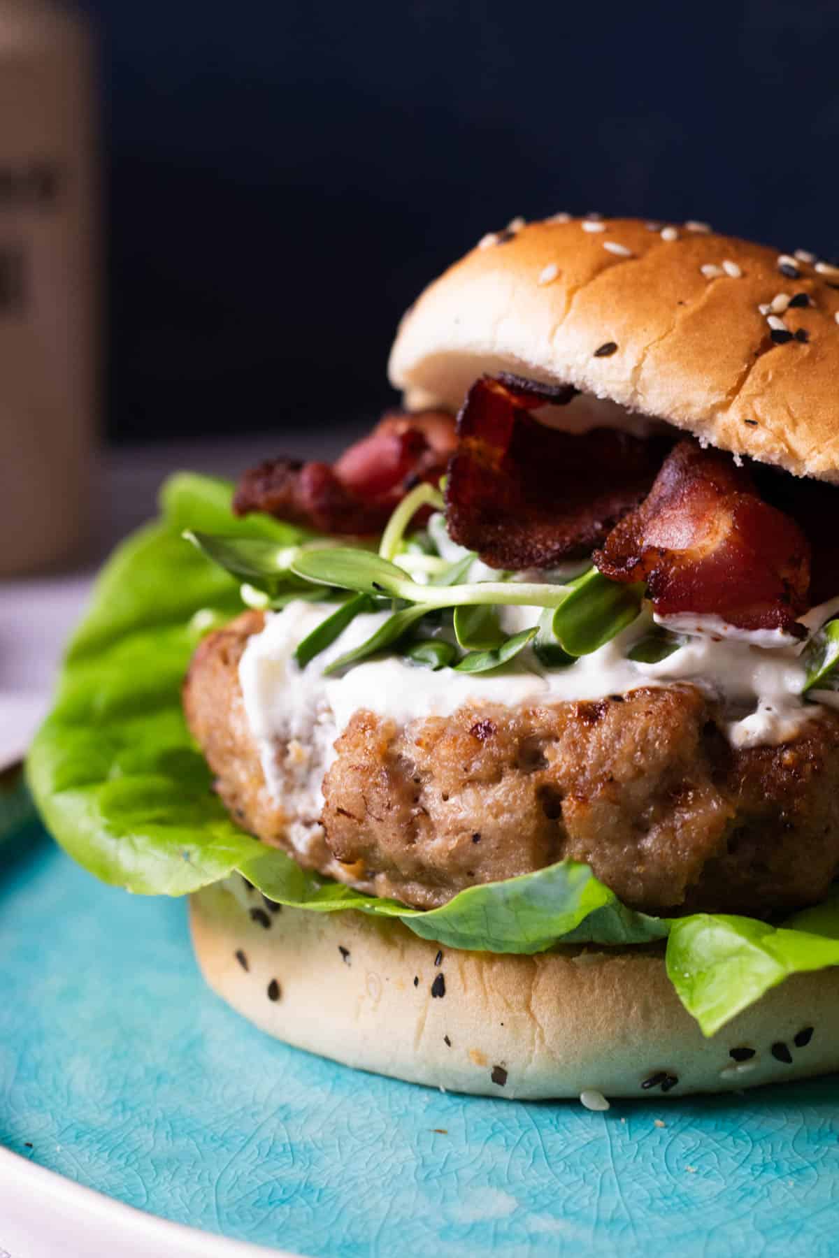 A turkey burger on a blue plate.