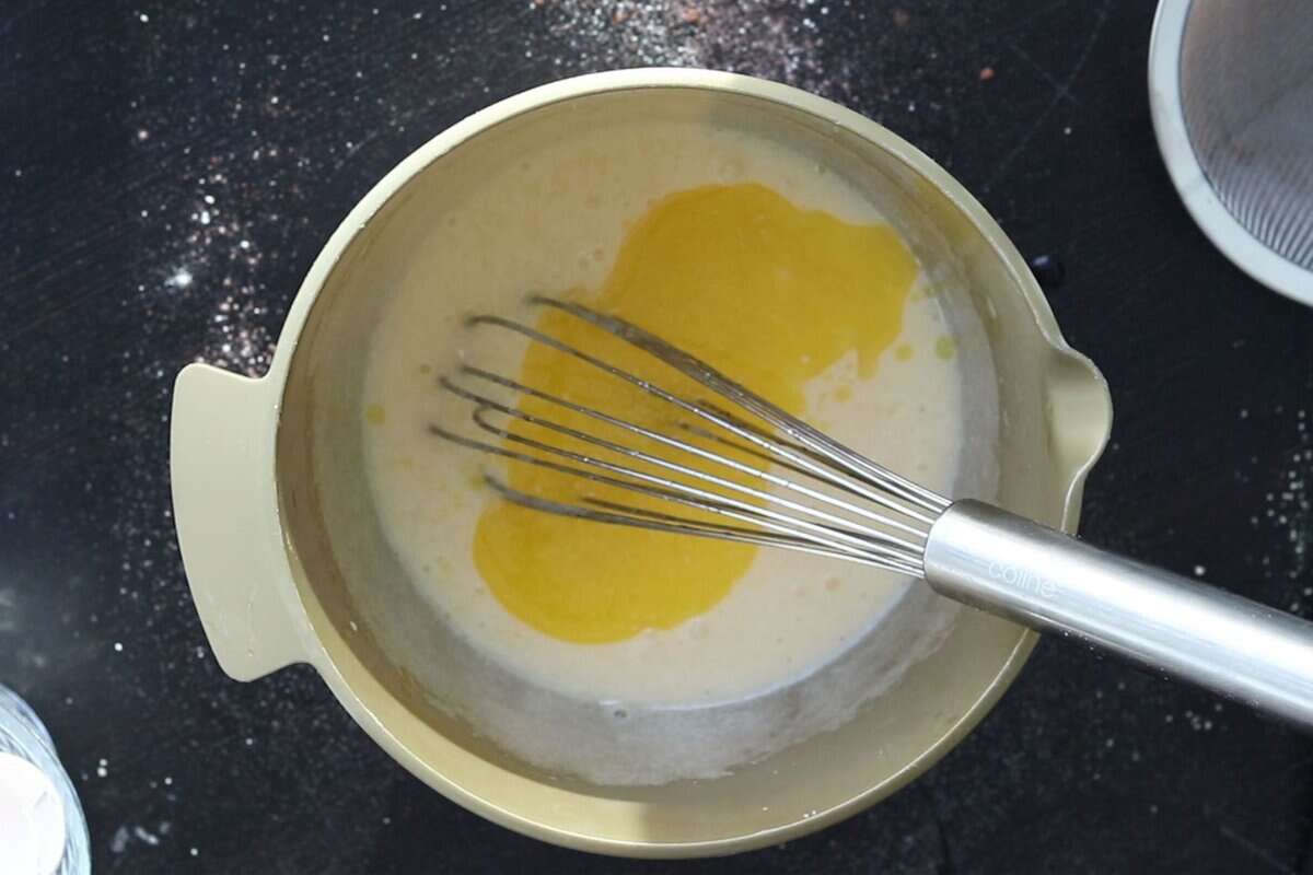 Adding butter to egg and sugar mixture to make walnut brownies.