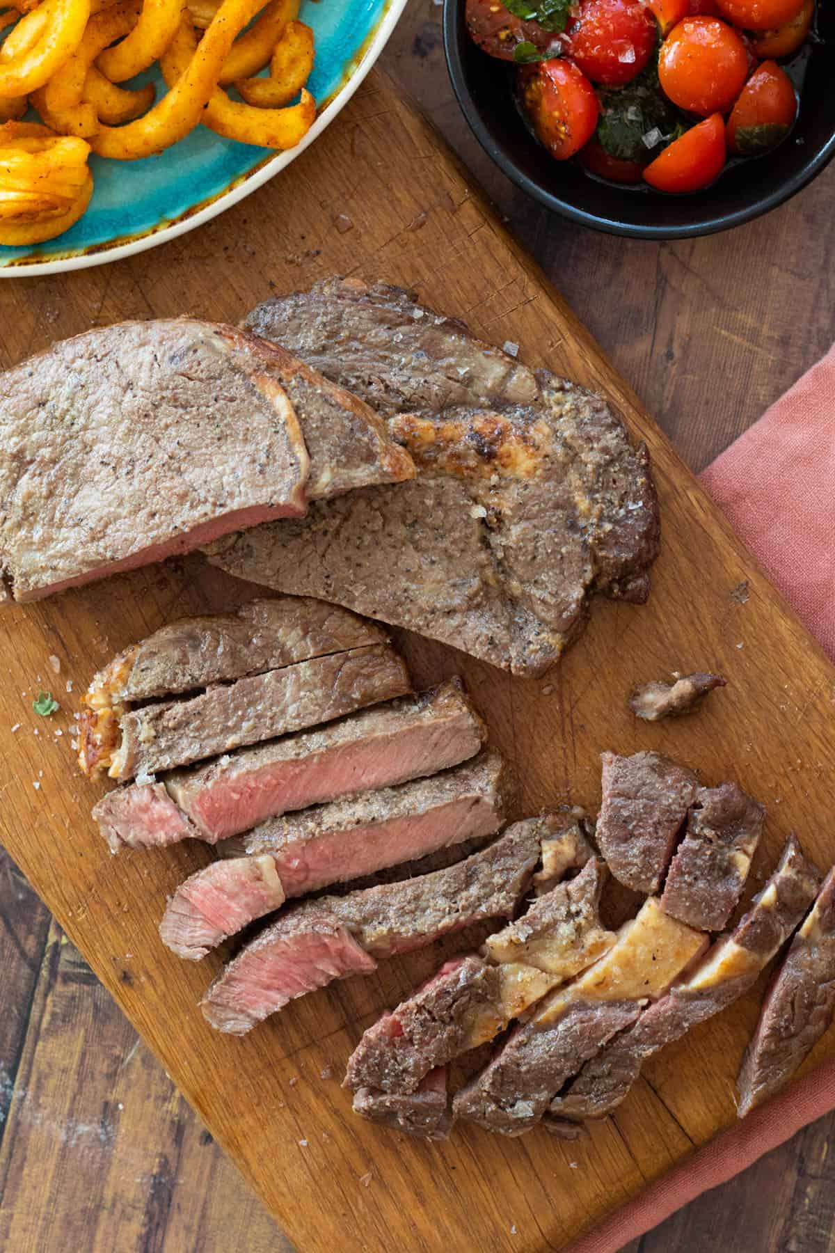 sliced steak on a wooden chopping board