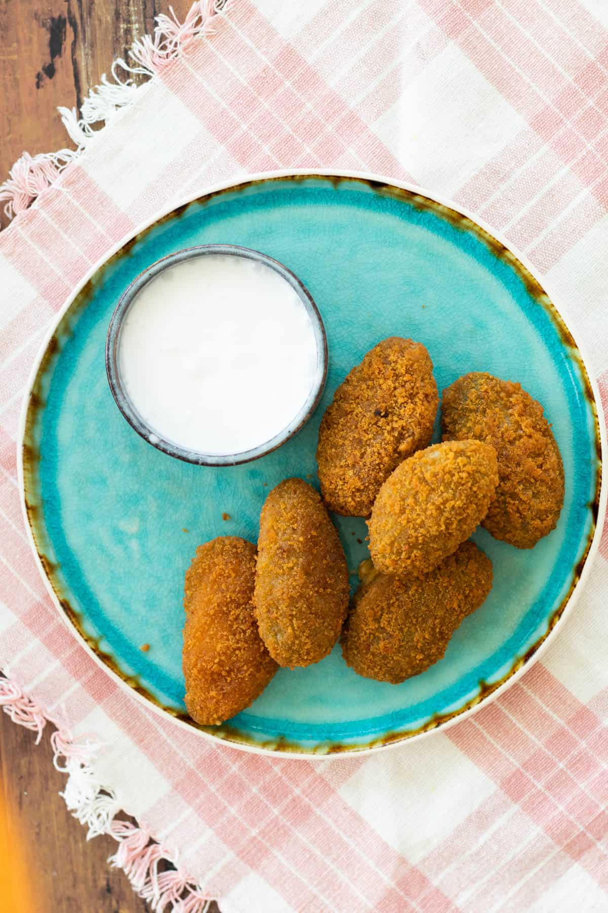 jalapeño poppers on a blue plate with a dip sauce.