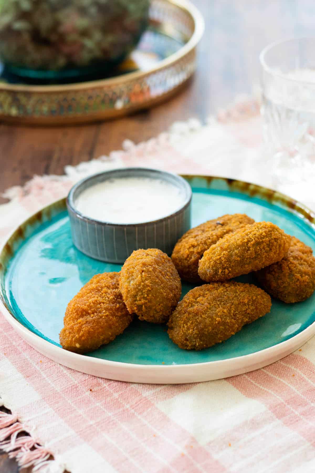 jalapeño poppers on a blue plate with a dip sauce.