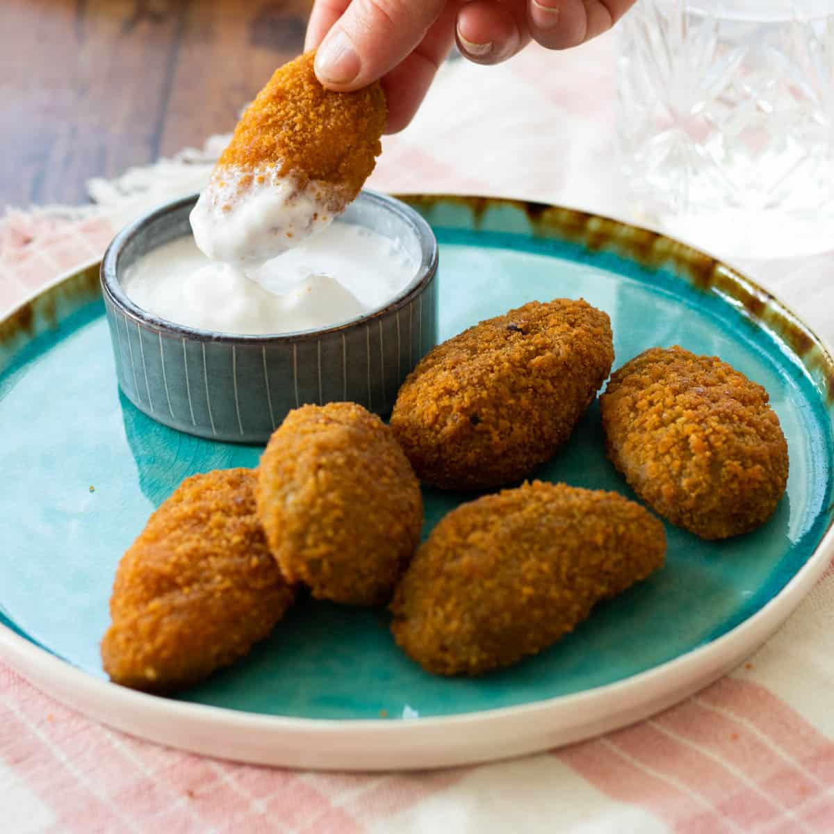 jalapeño poppers on a blue plate with a dip sauce