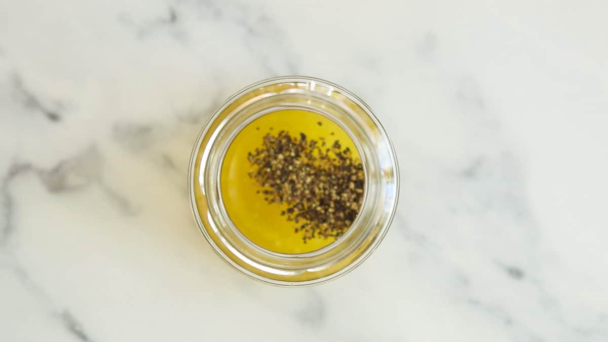 All ingredients for honey lemon vinaigrette in a jar.