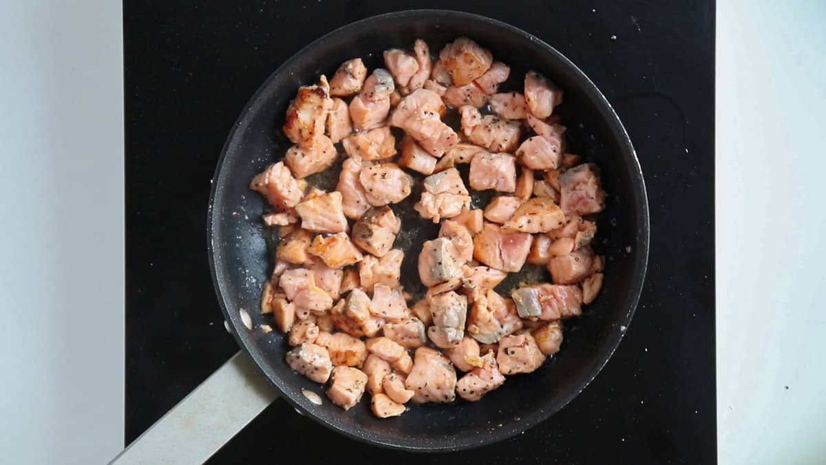 Seared salmon in a pan.