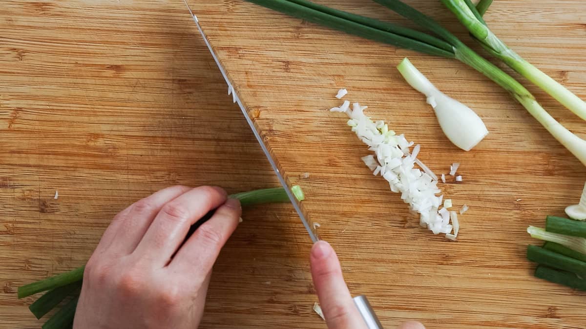 Slicing the tops of a green onion.