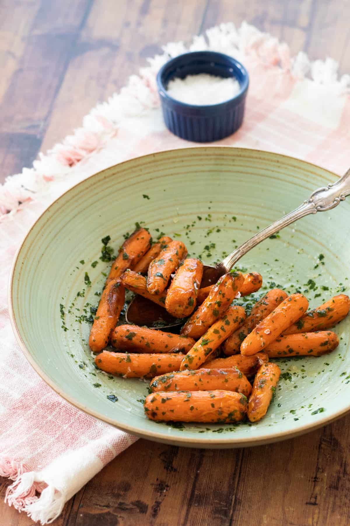 Air fryer baby carrots on a green plate.