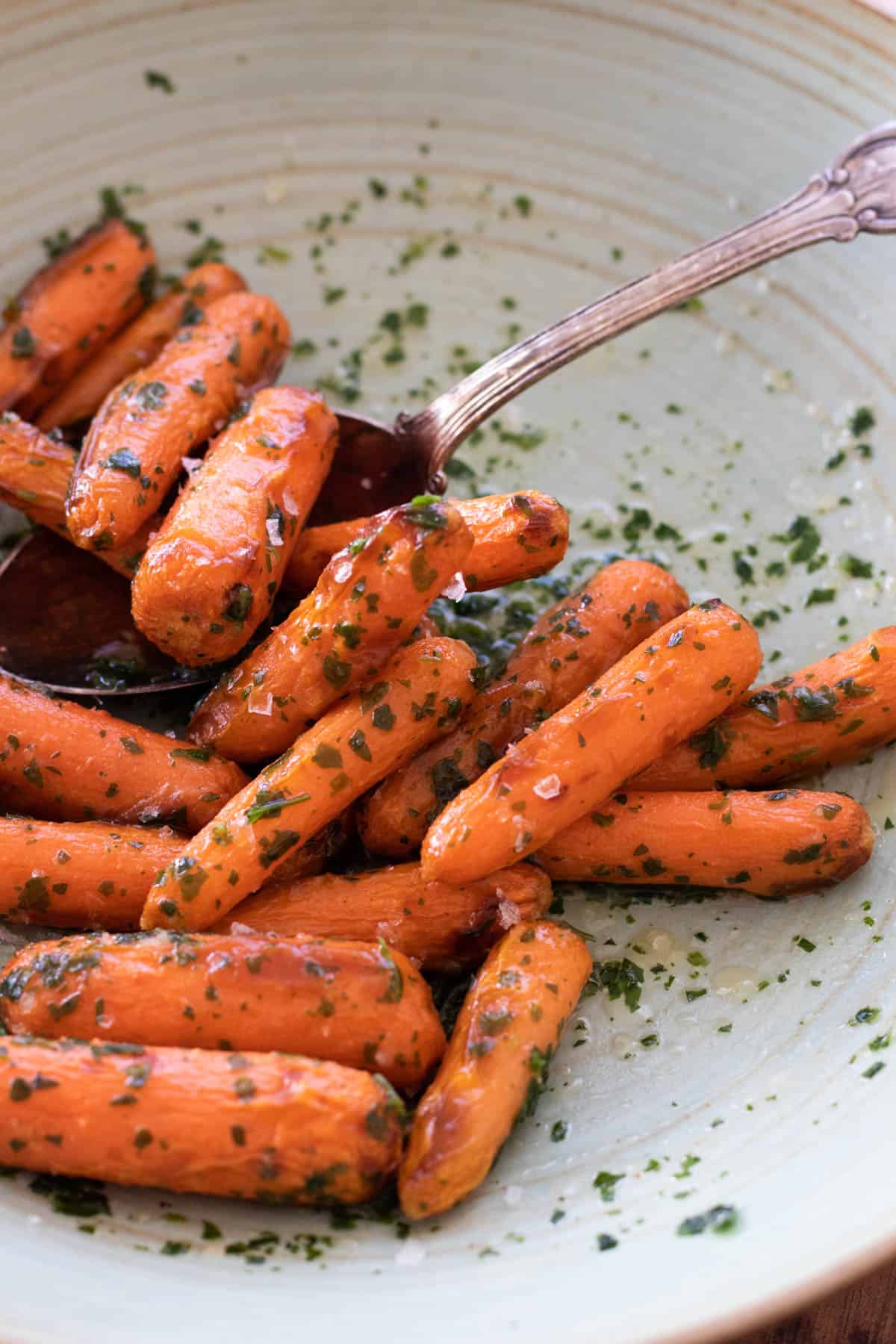 Air fryer baby carrots on a green plate.