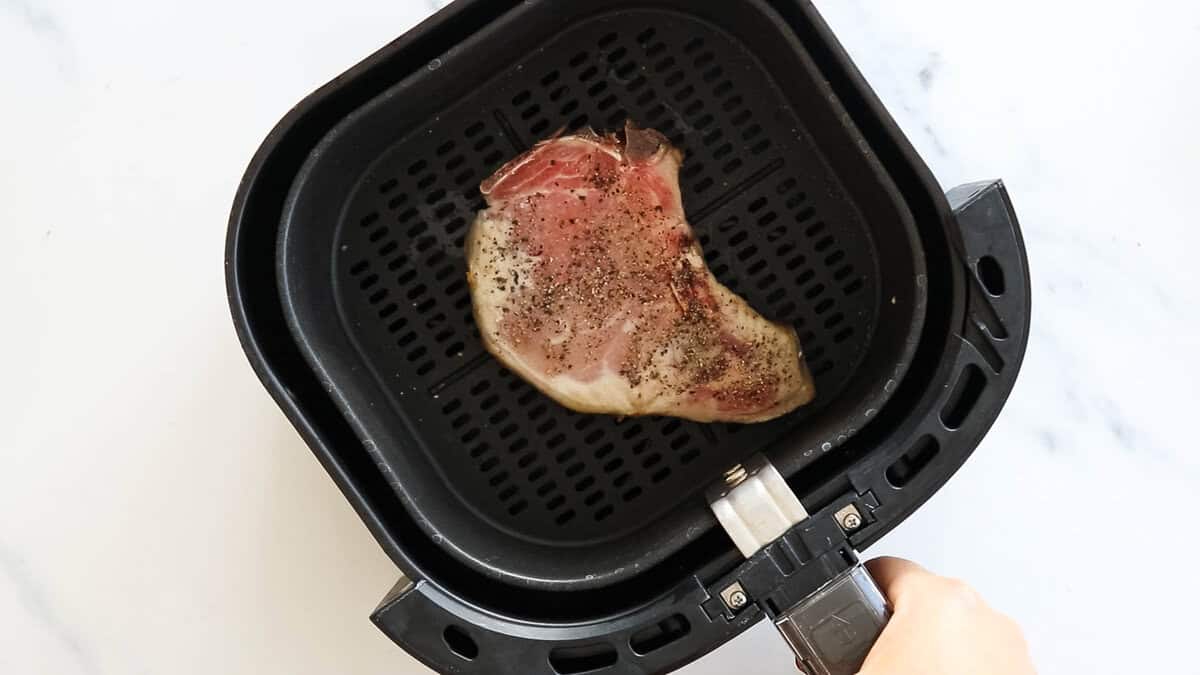 Seasoned pork chop in air fryer.