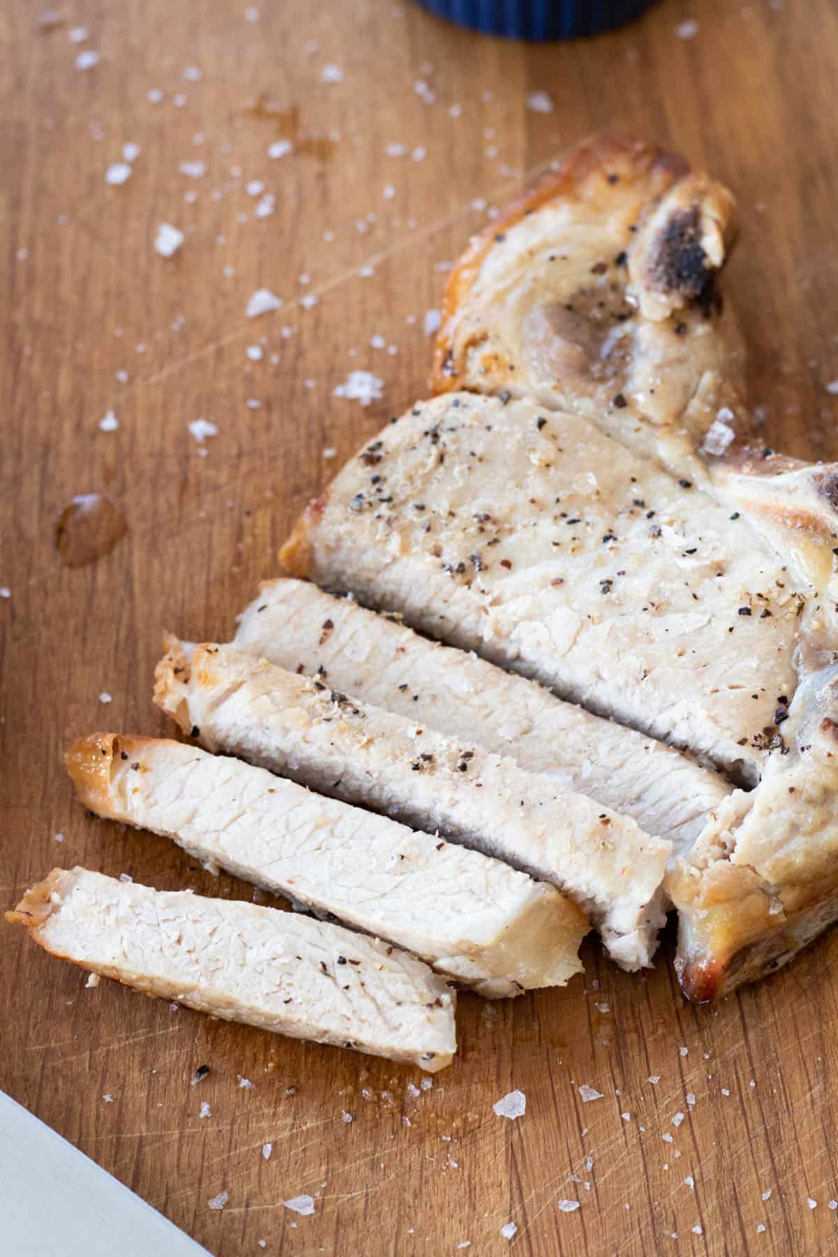 A sliced pork chop on a chopping board.