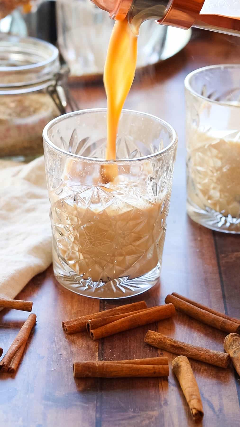 Pouring chai latte into a glass.