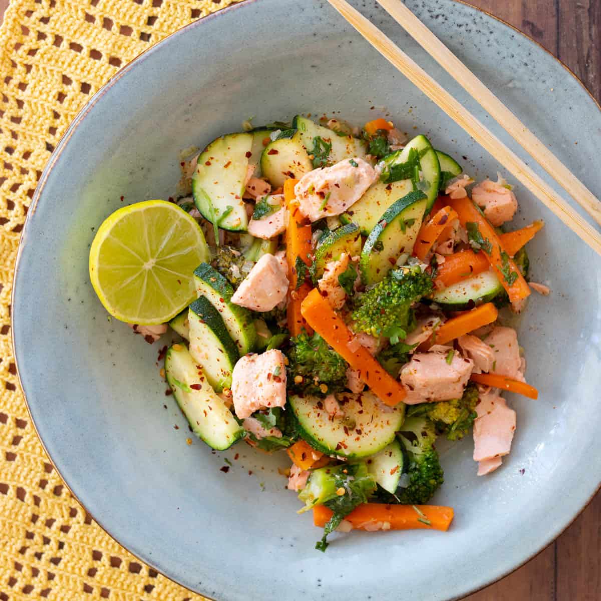 salmon stir fry in a blue bowl.