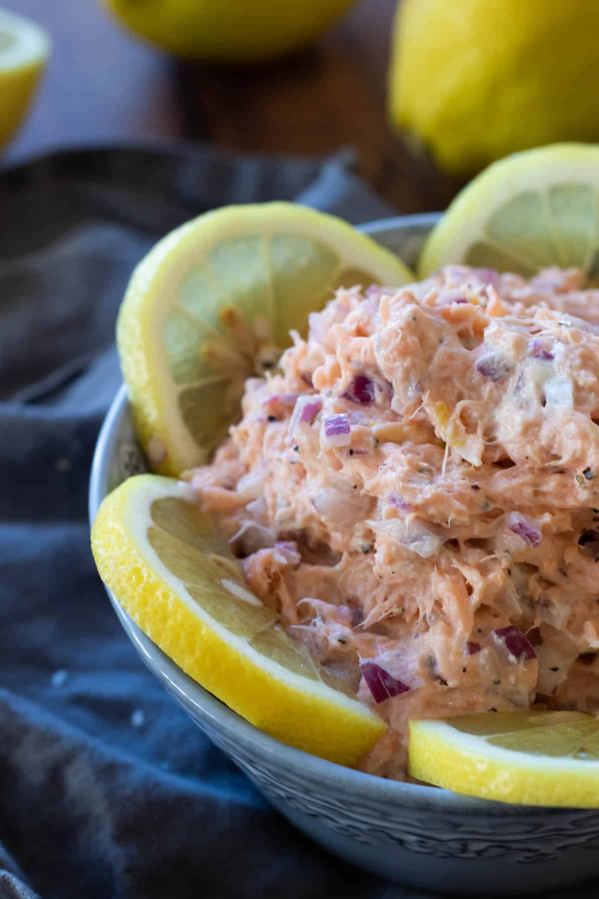 Smoked salmon pate in a bowl decorated with lemon slices.