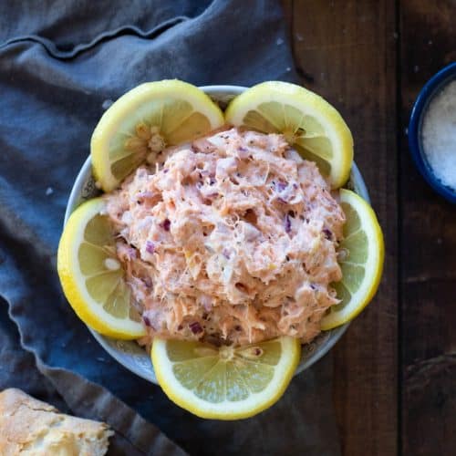 Smoked salmon pate in a bowl decorated with lemon slices.