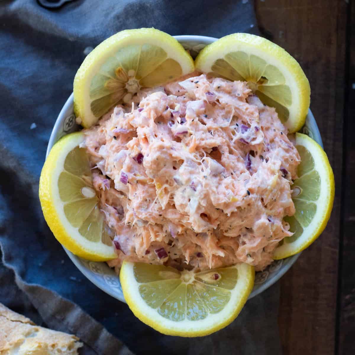 Smoked salmon pate in a bowl decorated with lemon slices.