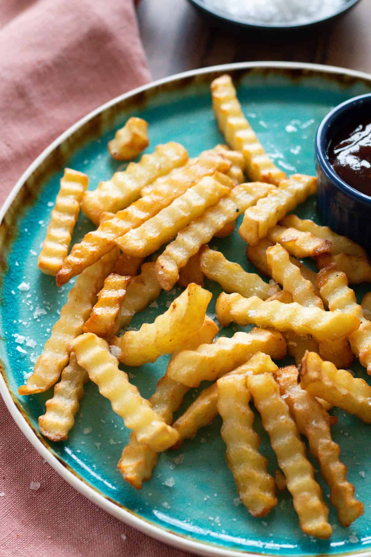 Crinkle fries on a blue plate.