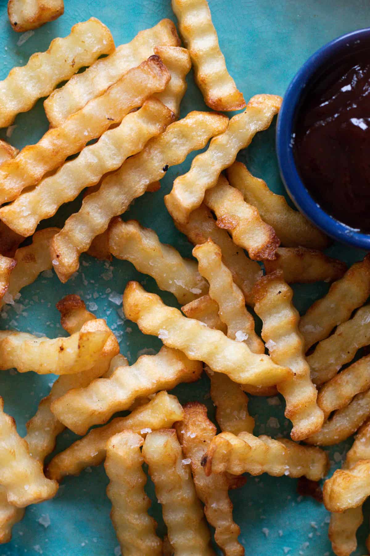 Crinkle fries on a blue plate.